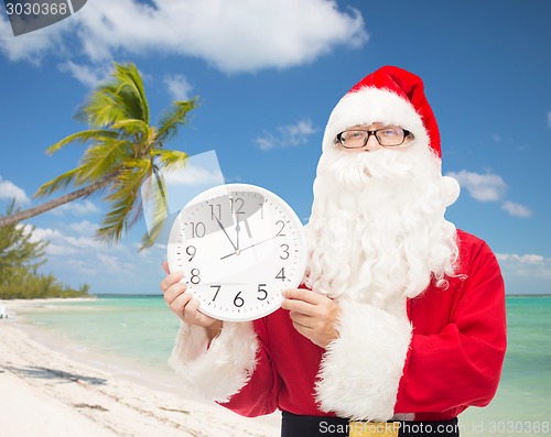 Image of man in costume of santa claus with clock