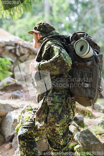 Image of young soldier with backpack in forest