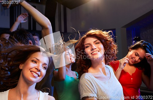 Image of smiling friends dancing in club