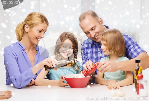 Image of happy family with two kids making salad at home
