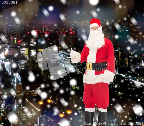 Image of man in costume of santa claus showing thumbs up