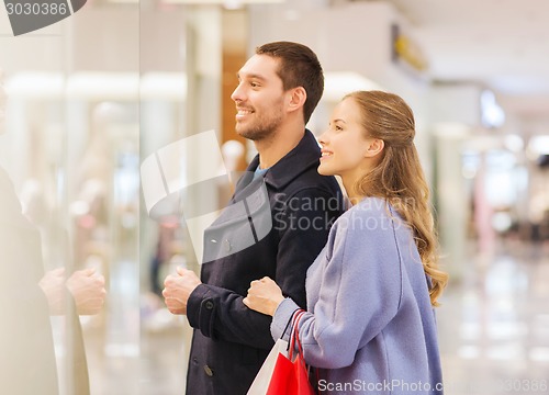 Image of happy young couple with shopping bags in mall