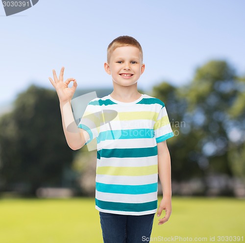 Image of little boy in casual clothes making ok gesture