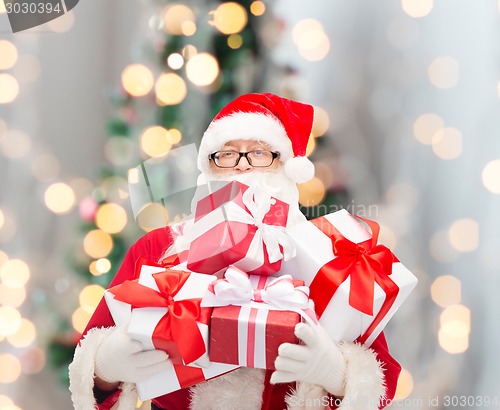 Image of man in costume of santa claus with gift boxes