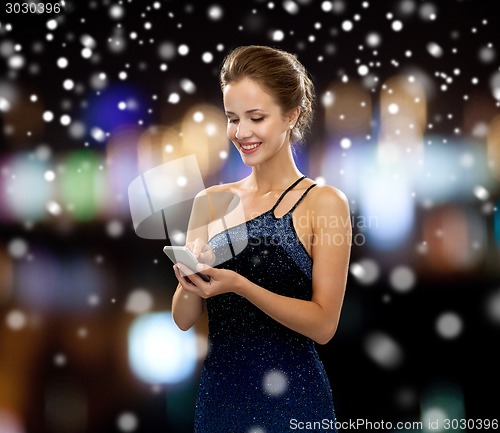 Image of smiling woman in evening dress with smartphone