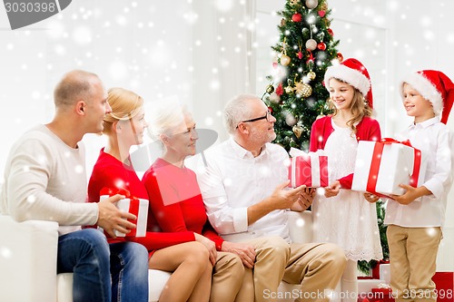 Image of smiling family with gifts at home