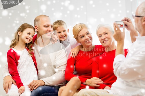 Image of smiling family with camera photographing at home