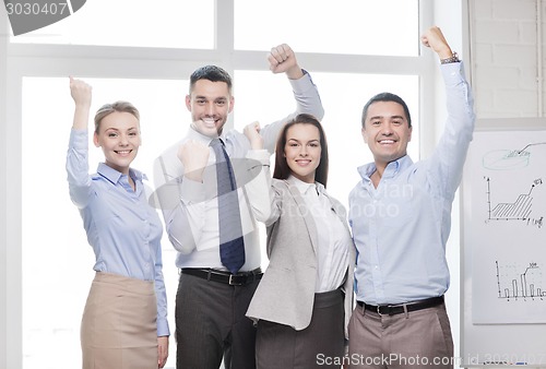 Image of business team celebrating victory in office