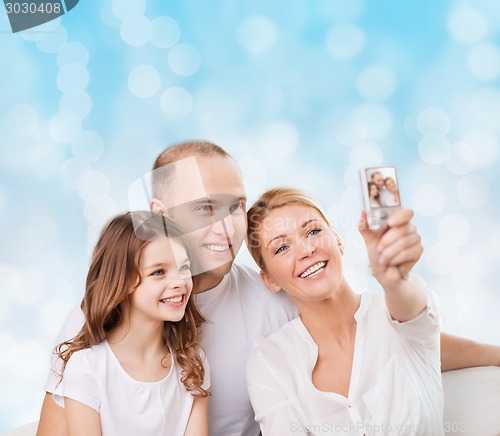 Image of happy family with camera at home