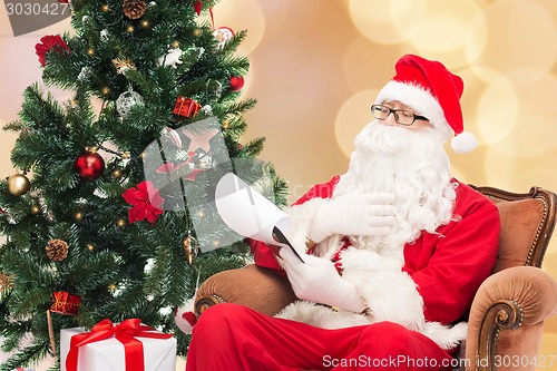 Image of man in costume of santa claus with notepad