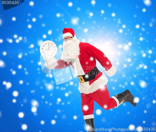 Image of man in costume of santa claus with clock