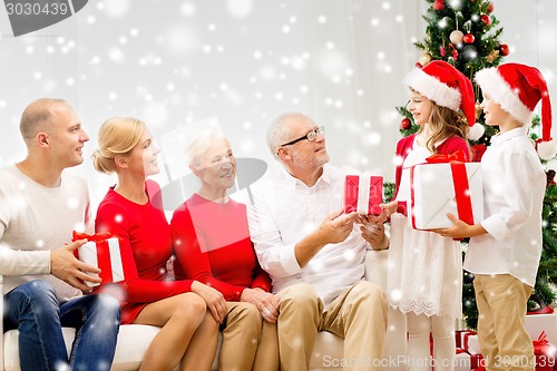 Image of smiling family with gifts at home