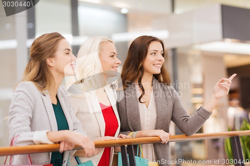 Image of happy young women with shopping bags in mall