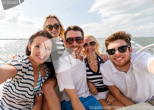 Image of smiling friends sitting on yacht deck