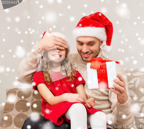 Image of smiling father and daughter holding gift box