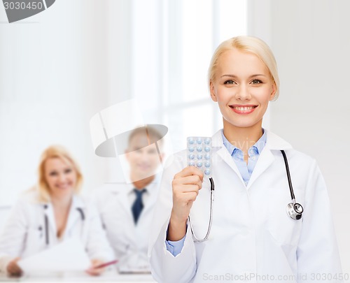 Image of smiling female doctor with pills