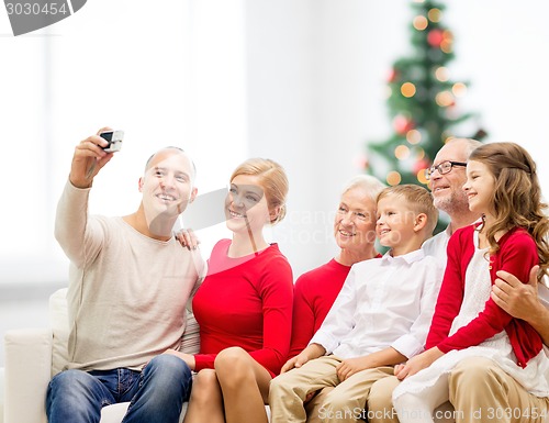 Image of smiling family with camera at home