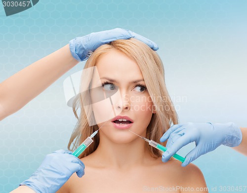 Image of woman face and beautician hands with syringes