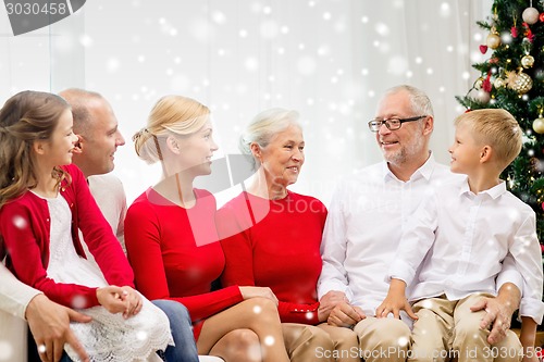 Image of smiling family sitting and talking at home