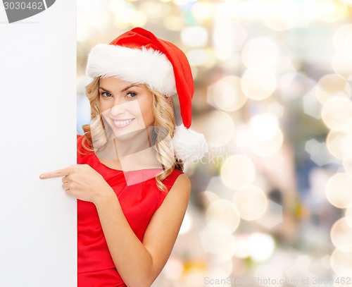 Image of smiling young woman in santa hat with white board