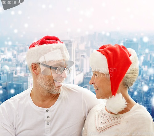 Image of happy senior couple in santa helper hats
