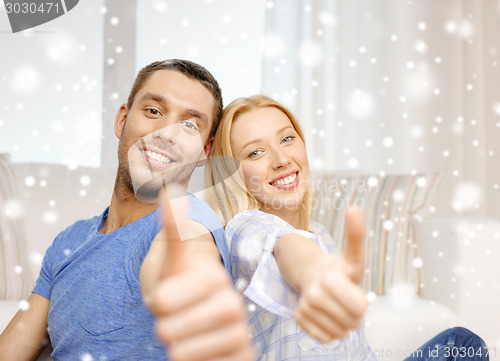Image of happy couple showing thumbs up and hugging