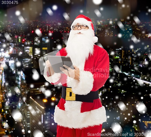 Image of man in costume of santa claus with tablet pc