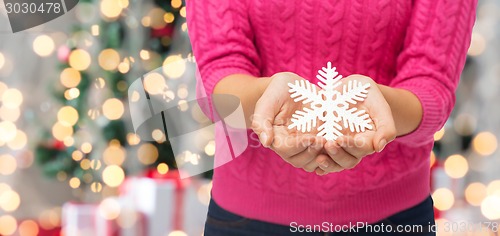 Image of close up of woman holding snowflake decoration