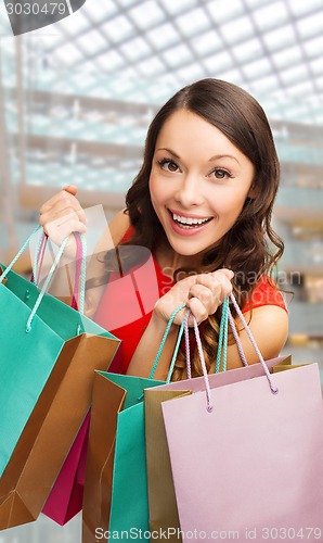 Image of smiling woman with colorful shopping bags