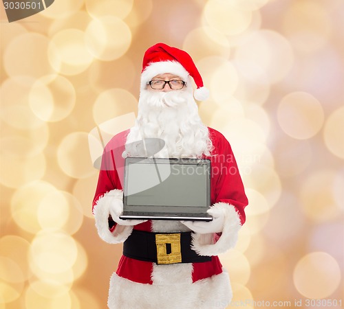 Image of man in costume of santa claus with laptop