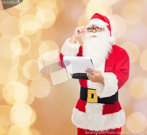 Image of man in costume of santa claus with notepad