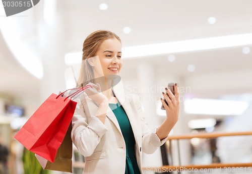 Image of woman with smartphone shopping and taking selfie
