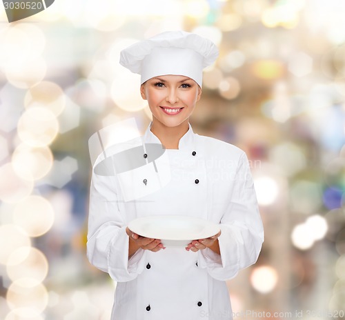 Image of smiling female chef with empty plate