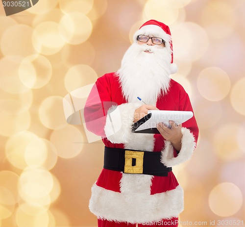 Image of man in costume of santa claus with notepad