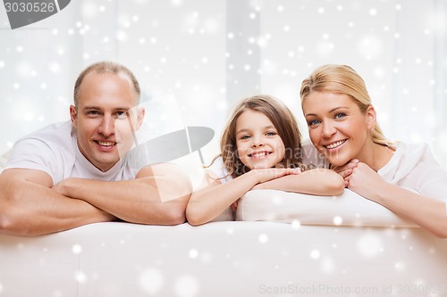 Image of smiling parents and little girl at home
