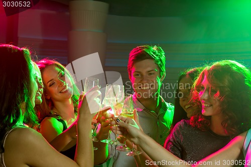 Image of smiling friends with glasses of champagne in club