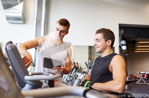 Image of men exercising on gym machine