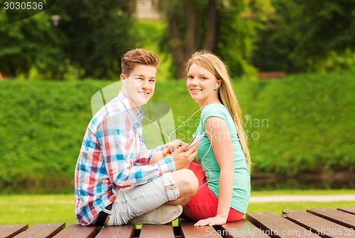 Image of smiling couple with smartphone and earphones