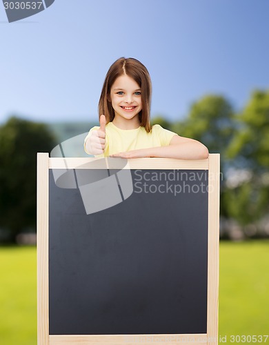 Image of happy little girl with blank blackboard