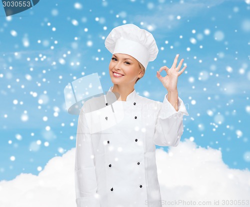Image of smiling female chef showing ok hand sign
