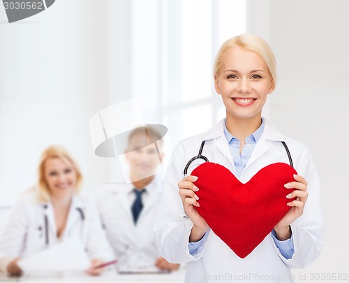 Image of smiling female doctor with heart and stethoscope