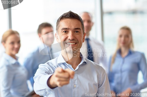 Image of group of smiling businesspeople meeting in office