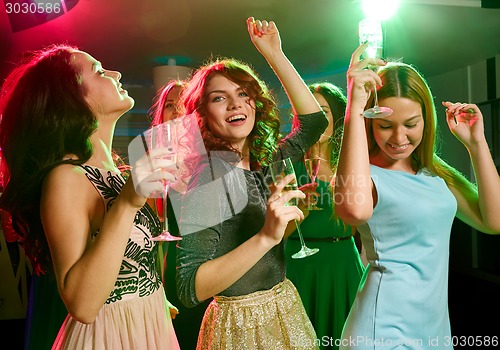 Image of smiling friends with glasses of champagne in club