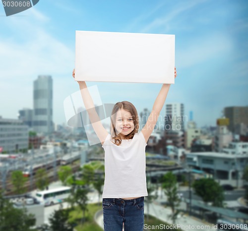Image of smiling little girl holding blank white board