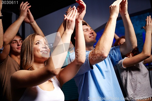 Image of smiling friends at concert in club