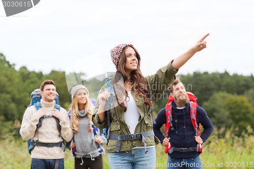 Image of smiling hikers with backpacks pointing finger