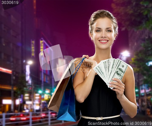 Image of smiling woman with shopping bags and money