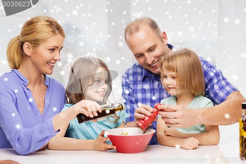 Image of happy family with two kids making salad at home