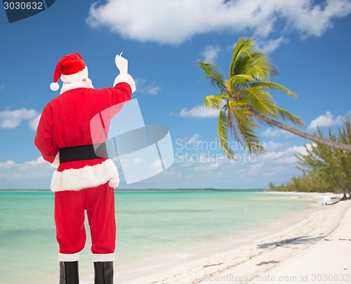 Image of man in costume of santa claus writing something