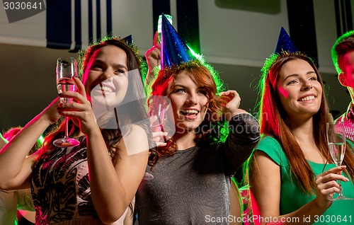 Image of smiling friends with glasses of champagne in club